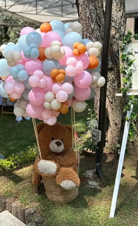 Globo aerostático de globos con oso de peluche en un jardín