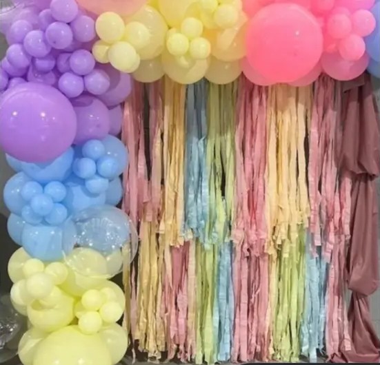 Muro de flecos y globos en tonos pastel