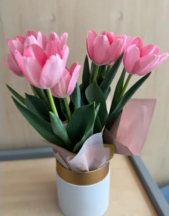Arreglo de tulipanes rosados en base blanca y dorada