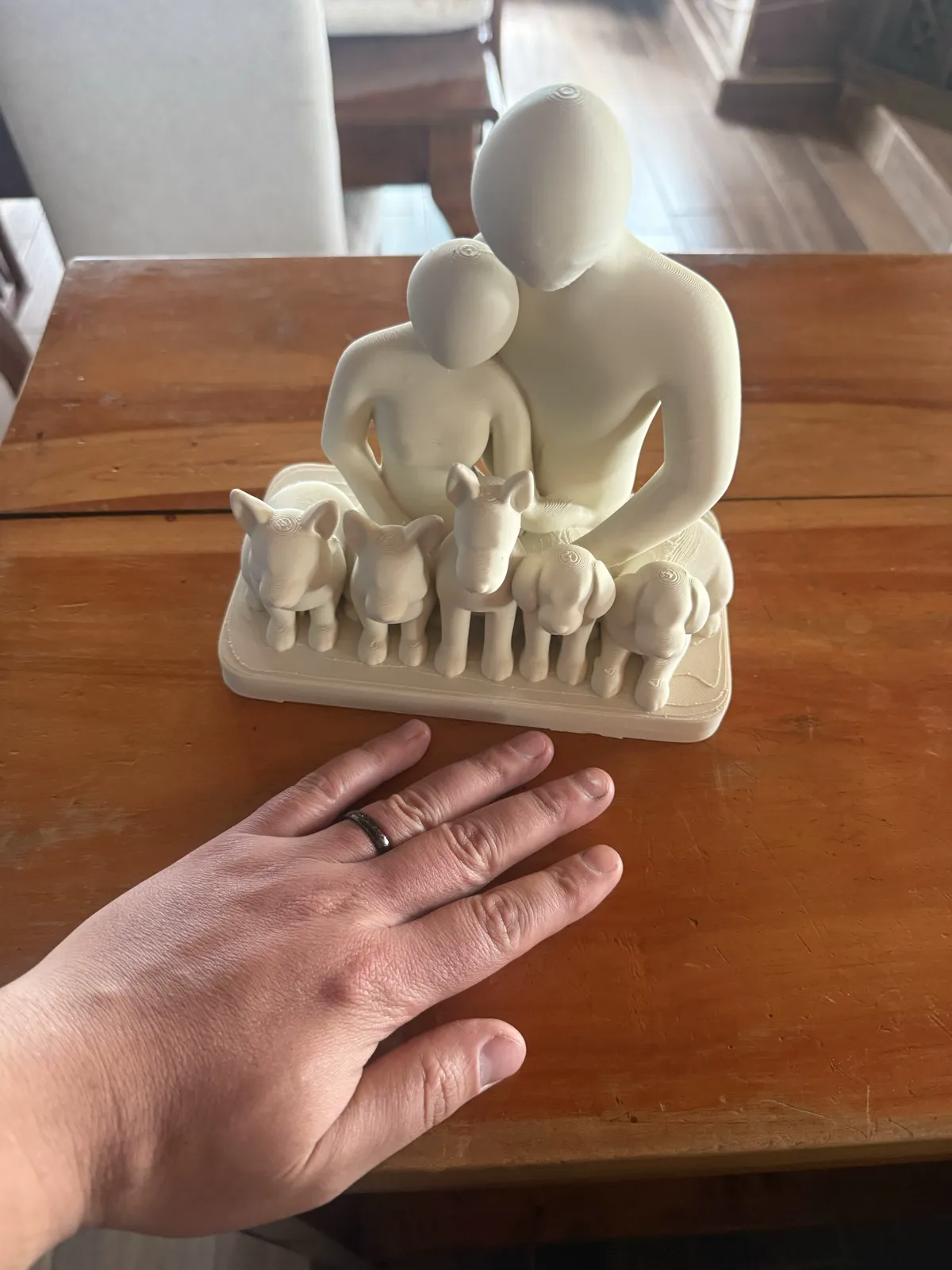 La misma pieza sobre una mesa, con una mano al lado como referencia visual de escala